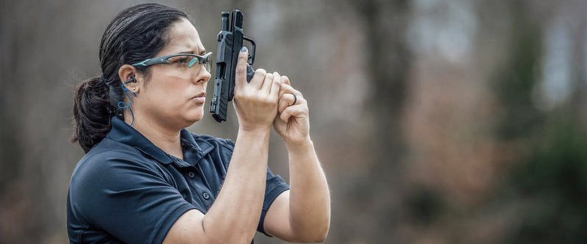 women loading a magazine into a handgun