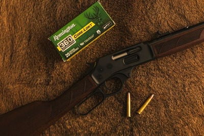 lever action rifle laying on a table with a box of Core-Lokt 360 Buckhammer and cartridges