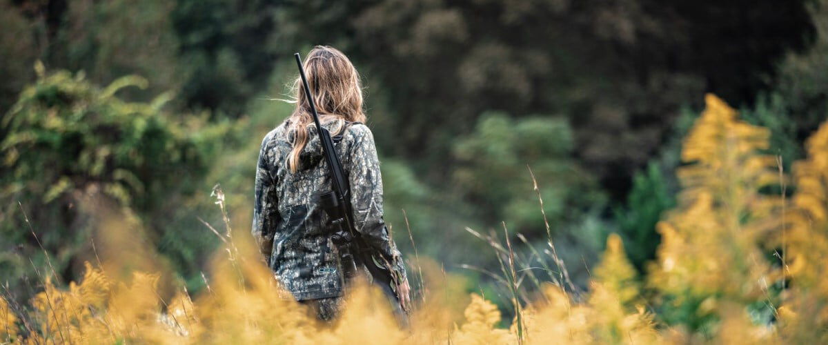 Aly from Alabama walking with a rifle on her shoulder