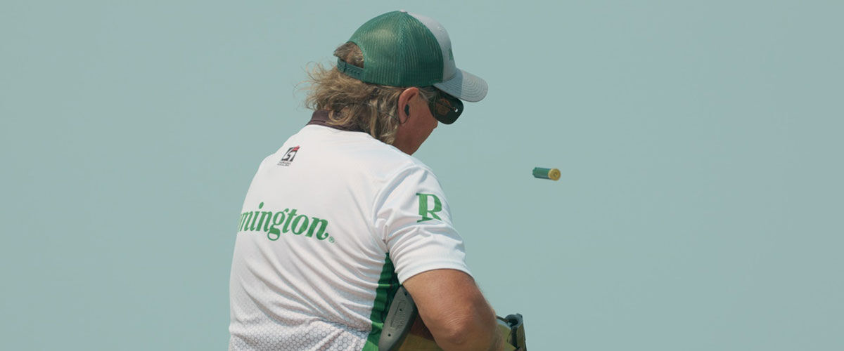 shooter wearing a Remington shirt ejecting a shotshell from a shotgun