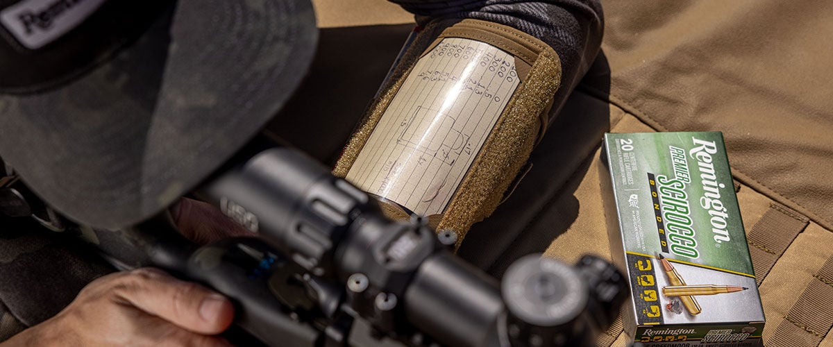 shooter looking down scope with Premier Scirocco box on a table